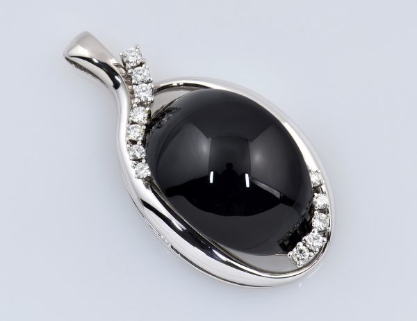 Anhänger 590/000 14 K Weißgold, Onyx und 12 Brillanten zus. 0,50 ct